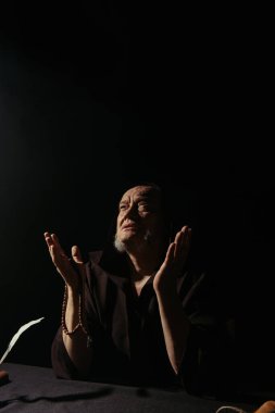 Yaşlı keşiş yukarılara bakıyor ve dua ediyor.