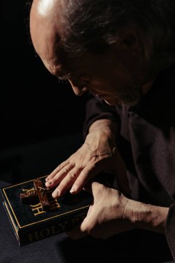 Ortaçağ keşişi kutsal İncil 'i ve haçı tutuyor. Siyah üzerine izole edilmiş.