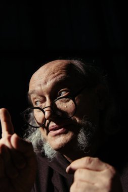 Düşünceli bir ortaçağ filozofu siyah üzerine izole edilmiş fikir işareti gösteriyor.
