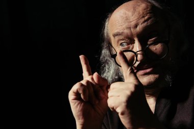 Gözlüklü ortaçağ filozofu siyah üzerine izole edilmiş fikir işaretleri gösteriyor.