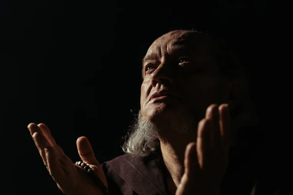 medieval monk praying at night while looking up isolated on black