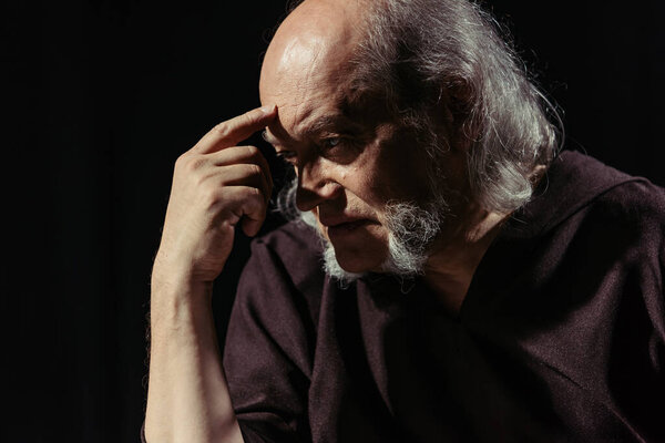 Средневековый религиозный философ трогает лоб и мыслит изолированно на черном