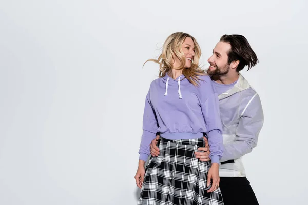 Happy Man Hugging Cheerful Woman Purple Sweatshirt Skirt While Looking — Stock Photo, Image