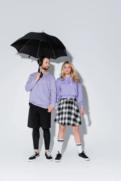 Full Length Stylish Couple Purple Sweatshirts Standing Black Umbrella Grey —  Fotos de Stock