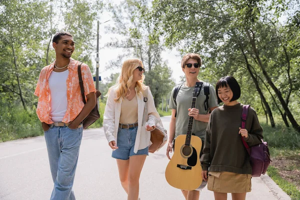 Happy Interracial Friends Guitar Backpacks Walking Countryside Summer Day — Stockfoto