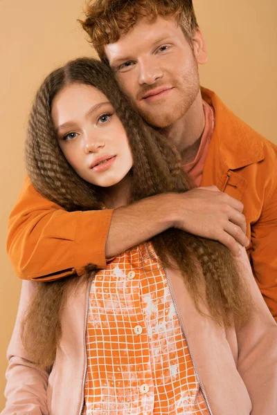 Smiling Young Redhead Man Hugging Girlfriend Wavy Hair Isolated Beige — Fotografia de Stock