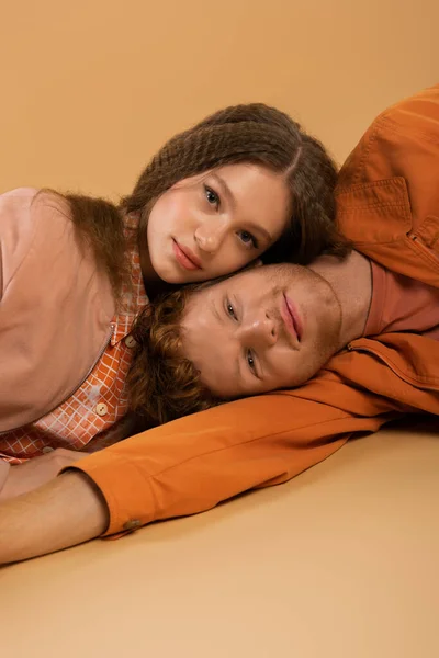 Pleased Young Redhead Man Lying Together Pretty Girlfriend Beige — Φωτογραφία Αρχείου