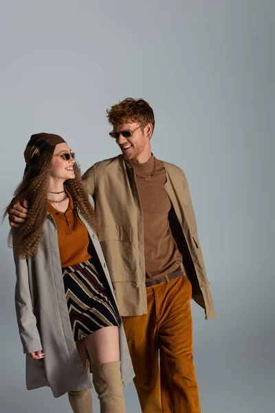 Cheerful Young Couple Autumnal Outfits Sunglasses Smiling Isolated Grey — Φωτογραφία Αρχείου