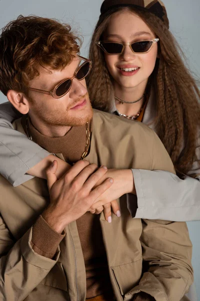 Cheerful Teenage Girl Sunglasses Headscarf Hugging Redhead Boyfriend Isolated Grey — Stockfoto