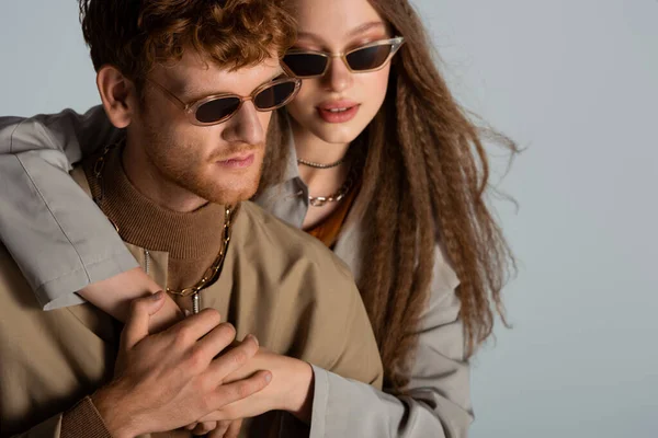 Stylish Teenage Girl Sunglasses Hugging Redhead Boyfriend Isolated Grey — стоковое фото