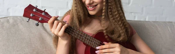 stock image cropped view of happy teenage girl in casual clothes playing ukulele, banner
