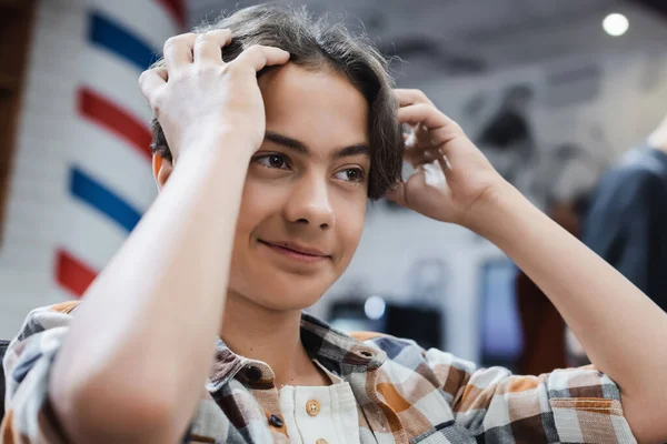 Souriant Adolescent Garçon Ajuster Les Cheveux Dans Salon Coiffure — Photo