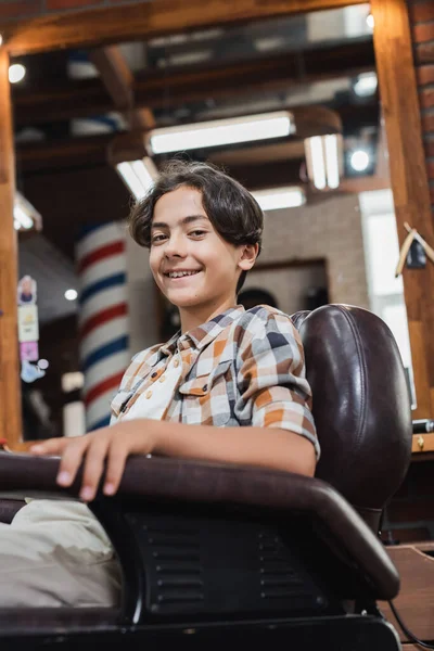Cliente Adolescente Sonriendo Cámara Mientras Está Sentado Sillón Barbería —  Fotos de Stock
