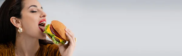 Joven Seductora Mujer Comiendo Sabrosa Hamburguesa Aislado Gris Bandera — Foto de Stock