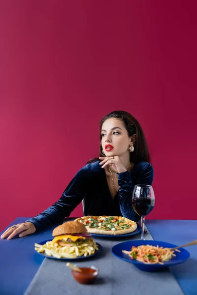 Брюнетка Женщина Велюровом Платье Глядя Сторону Вкусной Еды Подается Синий — стоковое фото