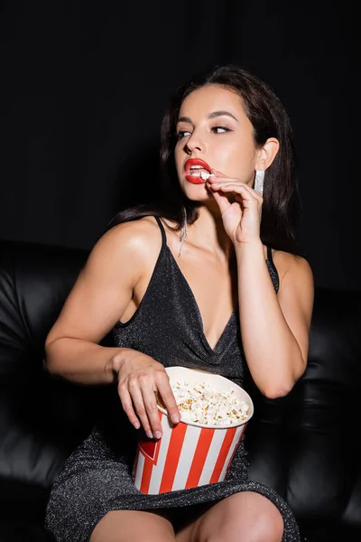 Sexy Vrouw Lurex Jurk Eten Popcorn Kijken Weg Geïsoleerd Zwart — Stockfoto