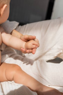 Annenin yatak odasında güzel bir bebekle el ele tutuşması görüntüsü. 