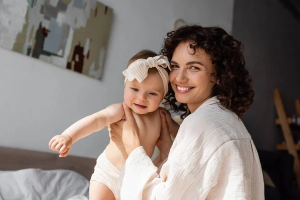 Cheerful Curly Mother Holding Arms Baby Girl Headband Bow — Stock Photo, Image