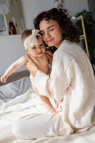 Lockige Mutter Mit Geschlossenen Augen Die Ein Glückliches Baby Stirnband — Stockfoto