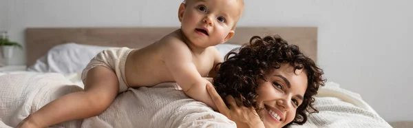 Spädbarn Barn Som Ligger Baksidan Lycklig Mor Med Lockigt Hår — Stockfoto