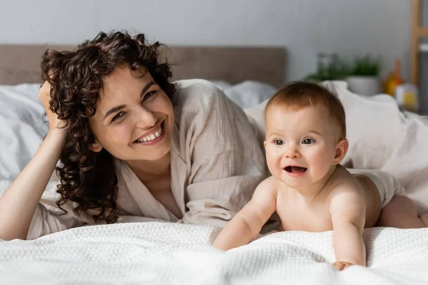 Glückliche Frau Mit Lockigem Haar Lächelt Während Sie Die Kamera — Stockfoto