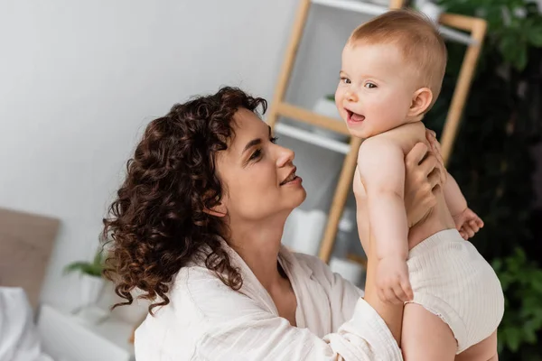 Compiaciuta Donna Con Capelli Ricci Sorridente Mentre Tiene Braccio Eccitato — Foto Stock