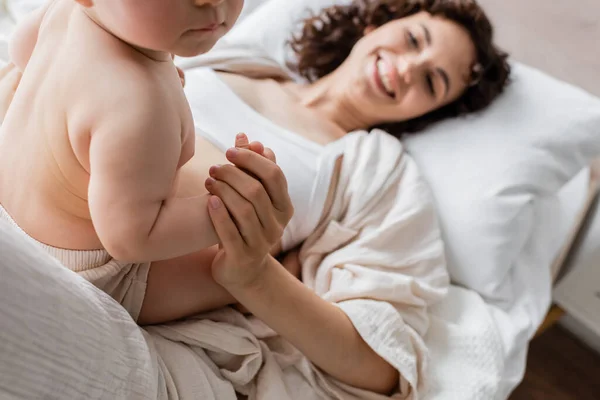 Cheerful Woman Loungewear Lying Bed Holding Hand Infant Daughter — Stock Photo, Image