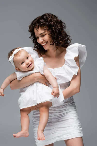 Χαμογελαστή Μητέρα Κοιτάζοντας Χαριτωμένο Κοριτσάκι Φόρεμα Απομονωμένο Γκρι — Φωτογραφία Αρχείου