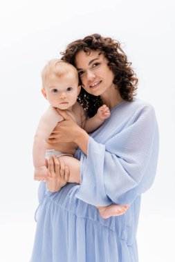 Beyaz kameraya bakan kıvırcık anne ve bebek kızı portresi 