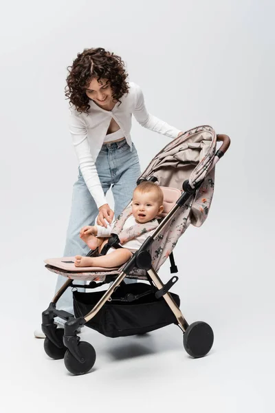 Smiling Woman Looking Baby Daughter Stroller Grey Background — Stock Photo, Image