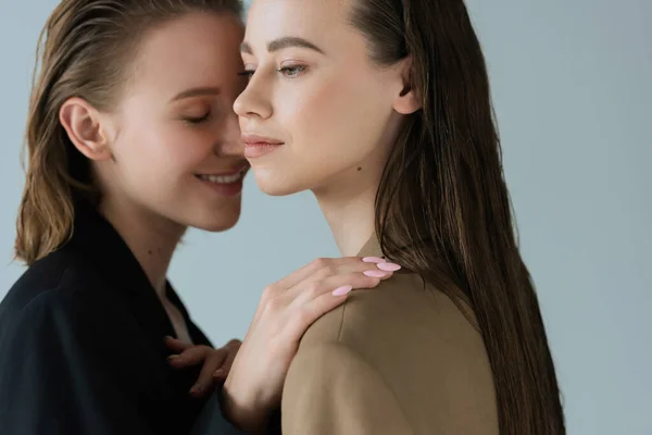 Молодая Женщина Улыбающаяся Трогающая Плечо Лесбиянки Изолированной Серых — стоковое фото