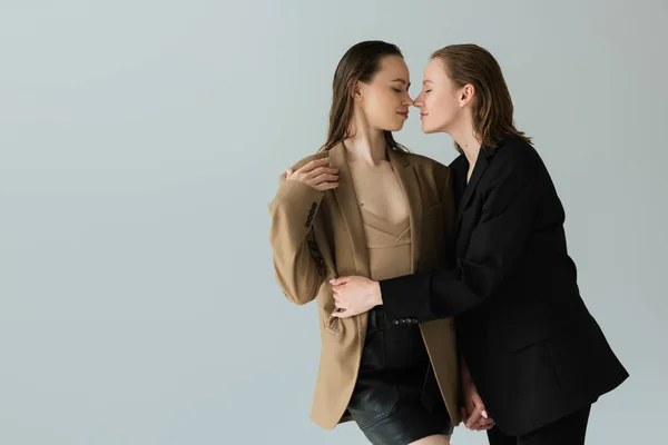 Joven Lesbiana Cogida Mano Con Novia Sonriente Abrazándola Aislada Gris — Foto de Stock