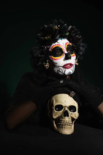 Kobieta Meksykańskim Dniu Martwego Makijażu Trzyma Czaszkę Ciemnozielonym Tle — Zdjęcie stockowe