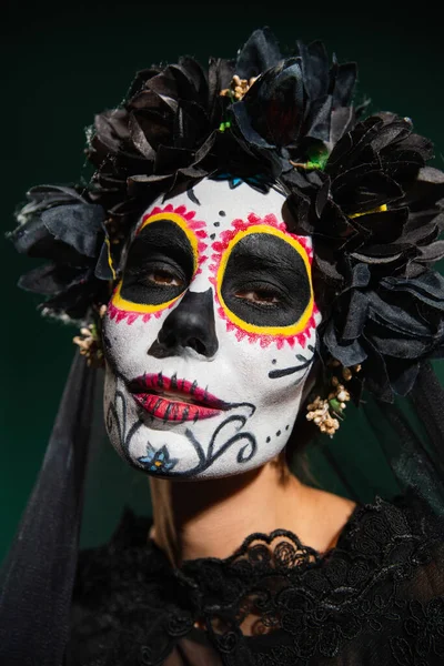メキシコの死の日の女性の肖像ハロウィンの衣装暗い緑の上に隔離されたカメラを見て — ストック写真