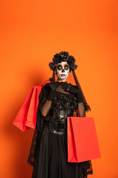 Zdumiona Kobieta Makijażu Catrina Czarny Straszny Kostium Trzymając Torby Zakupy — Zdjęcie stockowe