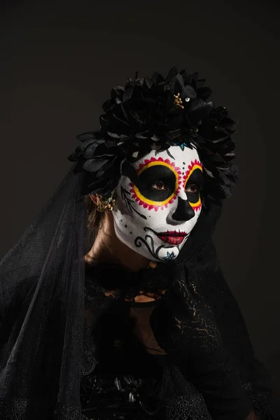 暗いハロウィンの衣装を着た女性と黒で隔絶された顔をした砂糖の頭蓋骨のメイク — ストック写真