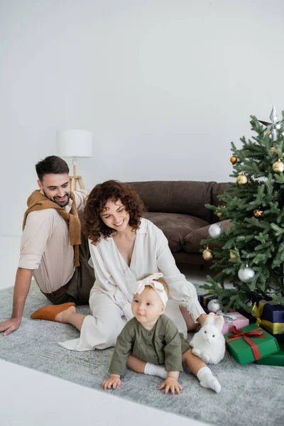 Glückliche Eltern Und Kleine Mädchen Sitzen Neben Geschmücktem Weihnachtsbaum Mit — Stockfoto