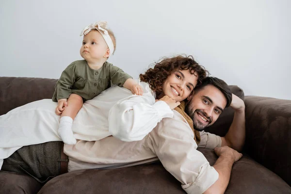 Neşeli Kıvırcık Kadın Küçük Kız Oturma Odasında Sakallı Kocasının Sırtında — Stok fotoğraf