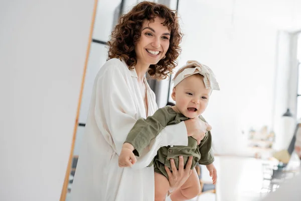 Glad Och Lockig Kvinna Vit Klänning Håller Spädbarn Dotter Armar — Stockfoto
