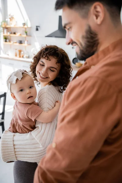 Gelukkig Moeder Houden Zuigeling Baby Meisje Buurt Glimlachen Wazig Echtgenoot — Stockfoto