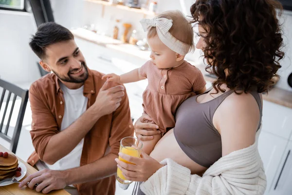Curly Woman Holding Arms Baby Daughter Bringing Orange Juice Husband — Stock Photo, Image