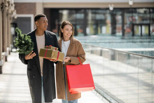 Fashionable Multiethnic Couple New Year Presents Small Christmas Tree Smiling — Stock Photo, Image