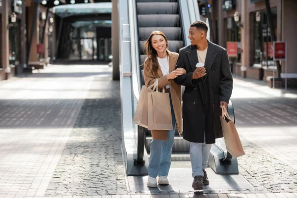 Happy Multiethnic Couple Stylish Clothes Holding Shopping Bags Paper Cup — Stock Photo, Image