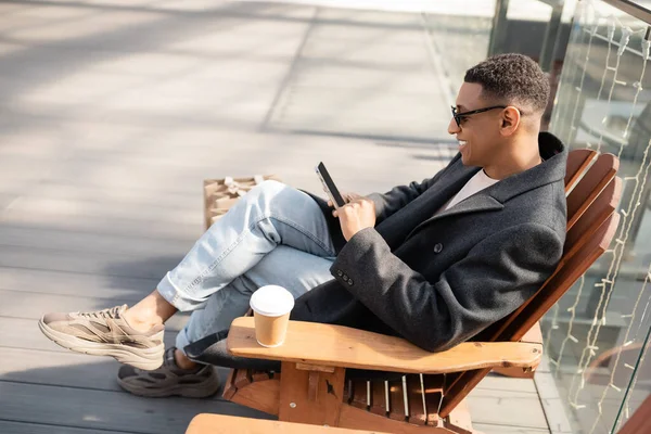 Homem Americano Africano Feliz Com Smartphone Sentado Assento Madeira Perto — Fotografia de Stock