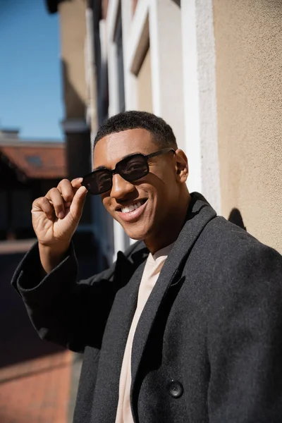 Trendy African American Man Adjusting Sunglasses Smiling Camera City Street — Stock Photo, Image