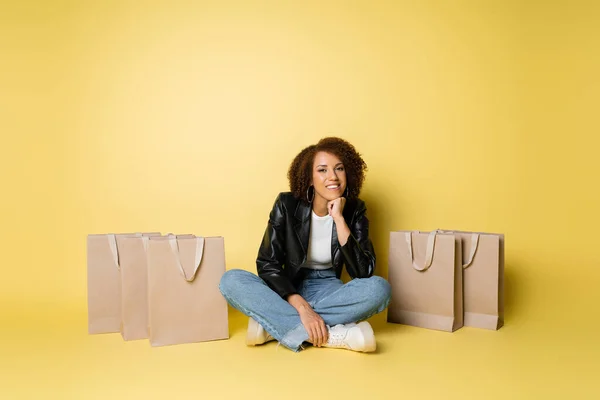 Full Längd Glad Afrikansk Amerikansk Kvinna Skinnjacka Och Jeans Sitter — Stockfoto