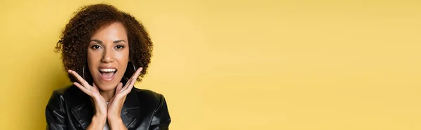 Şık Deri Ceketli Afro Amerikan Kadını Şaşırttı Sarı Pankartta Izole — Stok fotoğraf