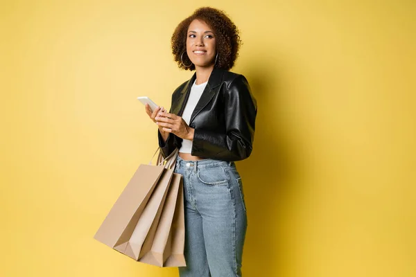 Mujer Afroamericana Complacida Elegante Chaqueta Cuero Con Bolsas Compras Teléfono — Foto de Stock