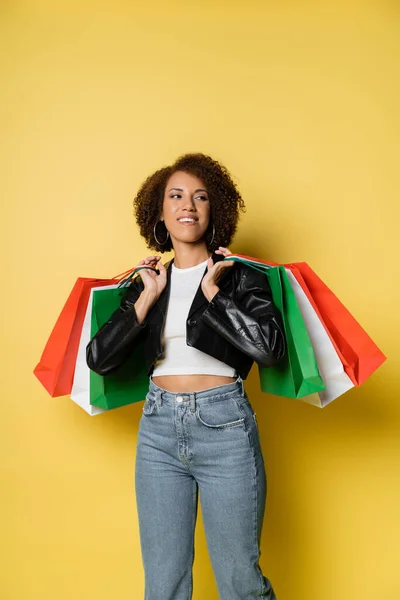 Sorrindo Mulher Americana Africana Jeans Jaqueta Couro Segurando Coloridos Sacos — Fotografia de Stock