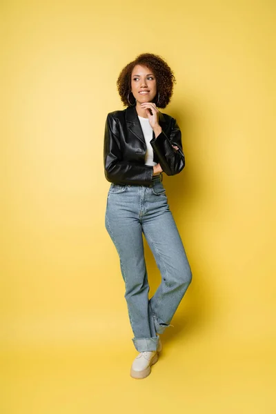Longitud Completa Sonriente Mujer Afroamericana Jeans Chaqueta Cuero Posando Amarillo — Foto de Stock